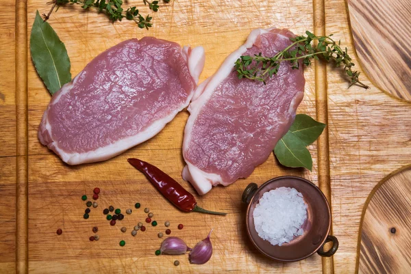 Bistecche di carne fresca su tagliere di legno leggero. Tonica — Foto Stock
