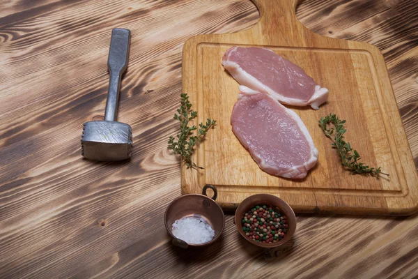 Fresh meat steaks on light wooden cutting board. Selective focus — Stock Photo, Image