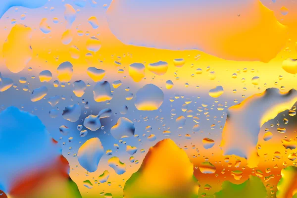 Gotas de água em um fundo a cores. Profundidade de campo rasa. Se... — Fotografia de Stock