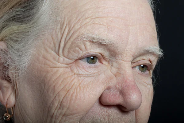 Portrait of elderly woman on dark background — Stock Photo, Image