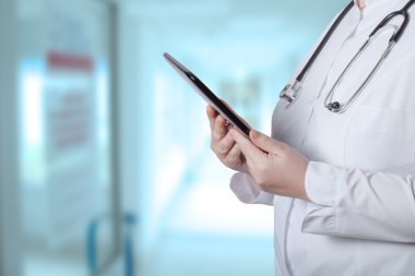 Bir kadın bir beyaz üniforma robe onu elektronik cihaz ile ha