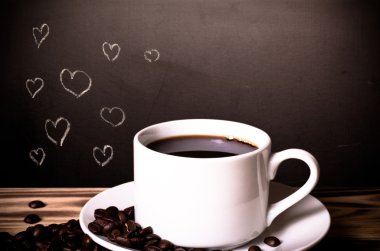 Fincan ile tahta bir masanın arkasında bir kara tahta üzerinde romantik Tema