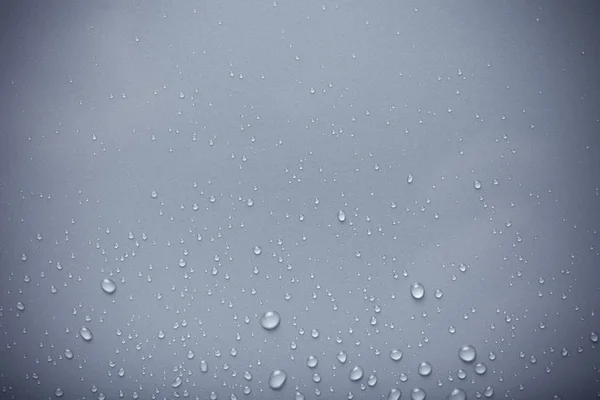 Wassertropfen auf einem farbigen Hintergrund. blau. gemildert — Stockfoto