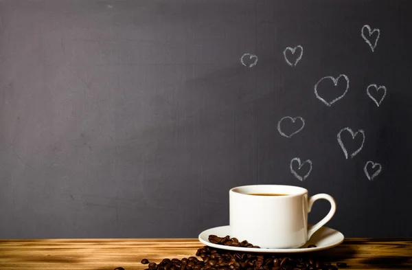 Romantisches Thema auf einer Tafel hinter einem Holztisch mit einer Tasse — Stockfoto