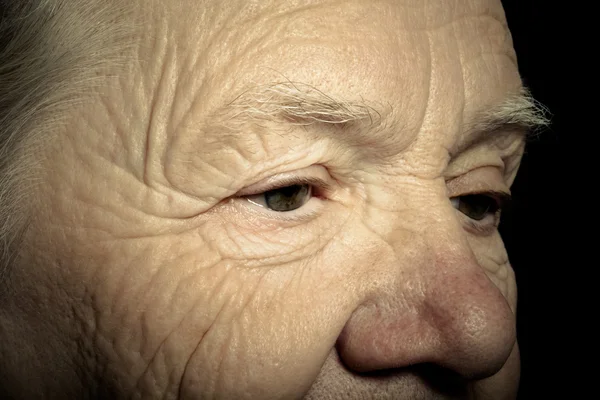 Retrato de mulher idosa sobre fundo escuro. Tonificado — Fotografia de Stock