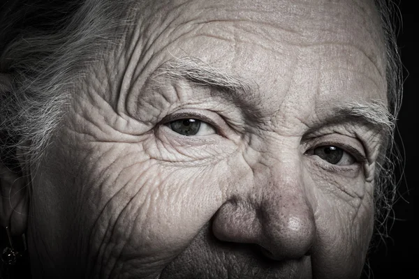 Portrait of elderly woman on dark background. Toned — Stock Photo, Image