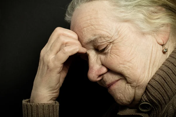 Koyu arka plan üzerinde yaşlı kadın portresi. Tonda