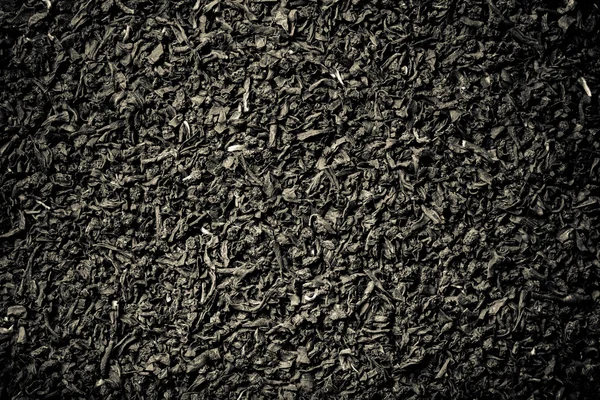 Folhas de chá preto seco como textura para o fundo. Tonificado — Fotografia de Stock