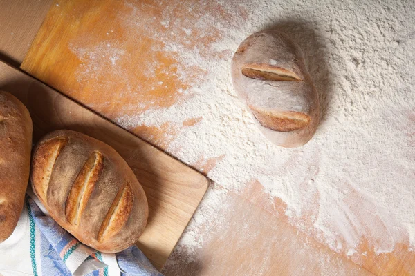 Pão caseiro fresco caiu em um monte de farinha — Fotografia de Stock