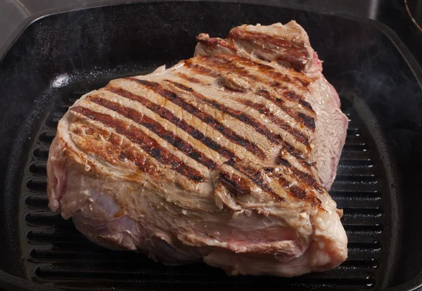 Великий шматок свіжого яловичого м'яса, приготованого на сковороді — стокове фото