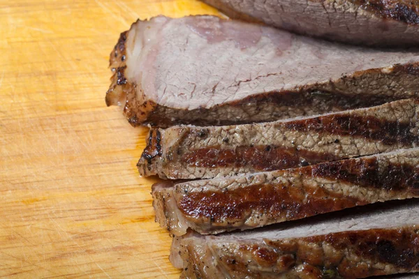 Large piece of fresh beef meat prepared on a grill pan on light — Stock Photo, Image