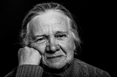 Portrait of elderly woman on dark background. Toned clipart