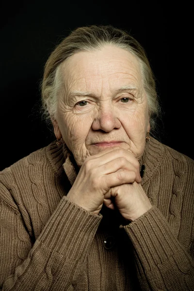 Portrait of elderly woman on dark background. Toned — Stock Photo, Image