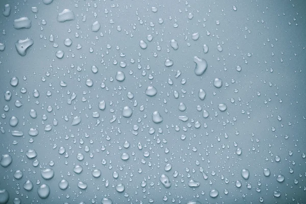 Wassertropfen auf einem farbigen Hintergrund. blau. gemildert — Stockfoto