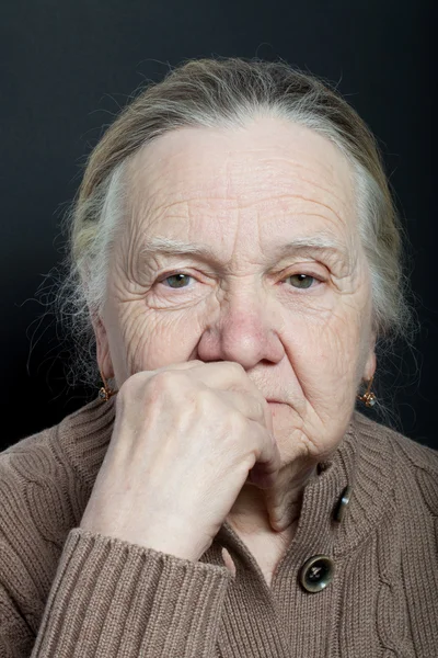 Portret van de bejaarde vrouw op donkere achtergrond — Stockfoto