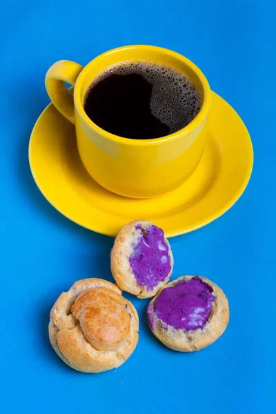 Fresh homemade profiteroles and cup of coffee on blue wooden tab — Stock Photo, Image