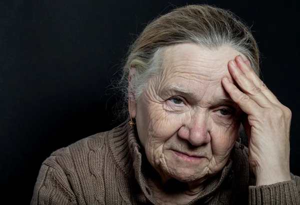 Portrait of elderly woman on dark background — Stock Photo, Image