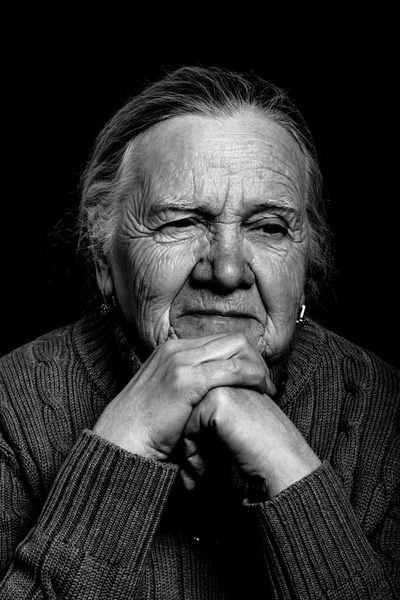 Portrait of elderly woman on dark background. Toned — Stock Photo, Image