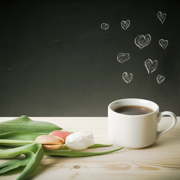 Tema romántico en una pizarra detrás de una mesa de madera con taza de —  Fotos de Stock