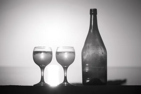 Botella y vasos de vid blanca con reflejos de casas y —  Fotos de Stock