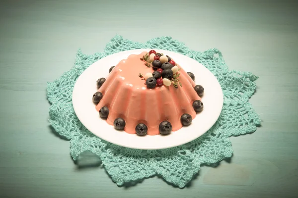 Bolo de mousse laranja com bagas na mesa de madeira azul. Tonificado — Fotografia de Stock