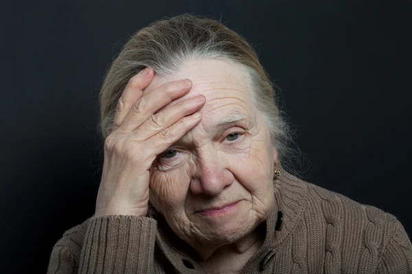 Portrait of elderly woman on dark background — Stock Photo, Image