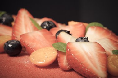 Parlak Mus kek üzerine birçok taze çilek. Seçici odak. Eder