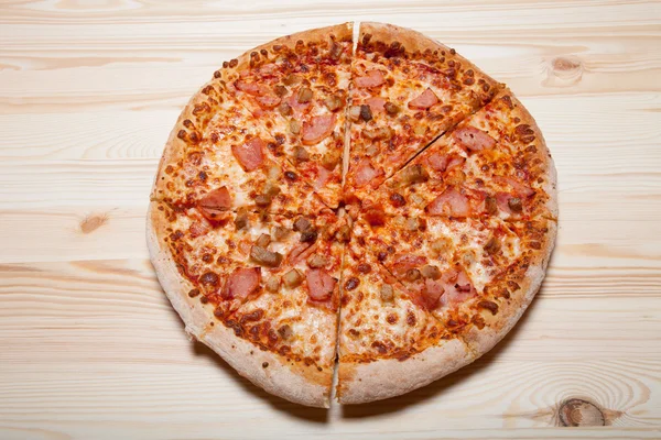 Свежая домашняя пицца на светлом деревянном столе — стоковое фото