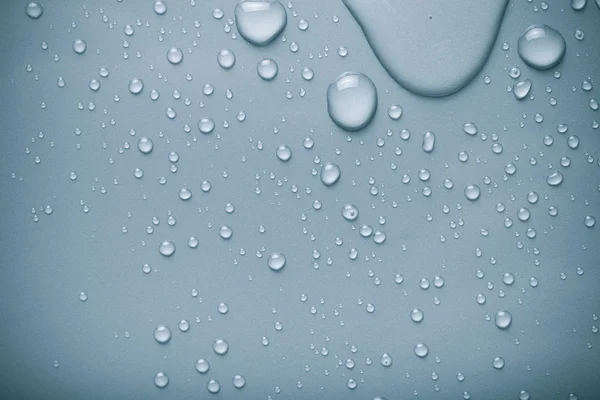 Wassertropfen auf einem farbigen Hintergrund. blau. gemildert — Stockfoto