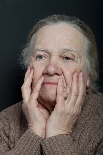 Koyu arka plan üzerinde yaşlı kadın portresi — Stok fotoğraf