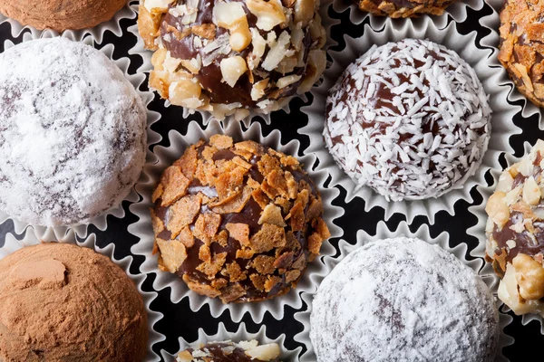 Chocolates caseiros redondos em diferentes tipos de decoração em papel su — Fotografia de Stock