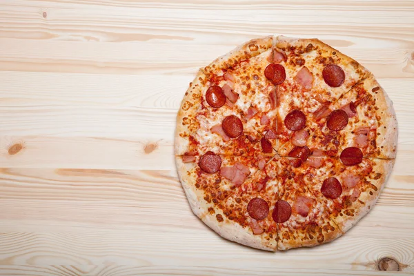 Fresh homemade pizza on light wooden table — Stock Photo, Image