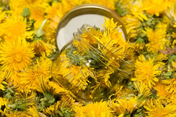 Tarro de vidrio sobre fondo natural de diente de león amarillo. Superficie de — Foto de Stock