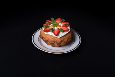 Taze kek krem ve siyah arka plan üzerine çilek