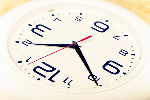 White wall clock with black arrows. Selective focus. Shallow dep — Stock Photo, Image