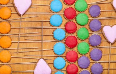 Gingerbread çerezleri eski woo üzerinde sopa üzerinde renkli mastik ile