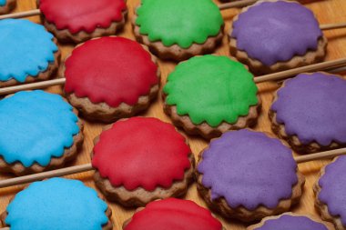 Gingerbread çerezleri eski woo üzerinde sopa üzerinde renkli mastik ile
