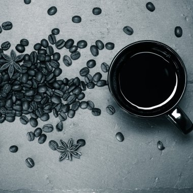 Kahve ve kahve tohumlar arduvaz arka plan üzerinde siyah kupa. Hedef