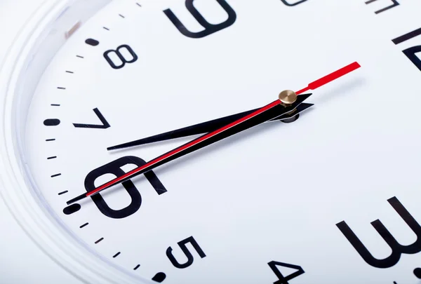 Reloj de pared blanco con flechas negras. Enfoque selectivo. Dep poco profundo —  Fotos de Stock