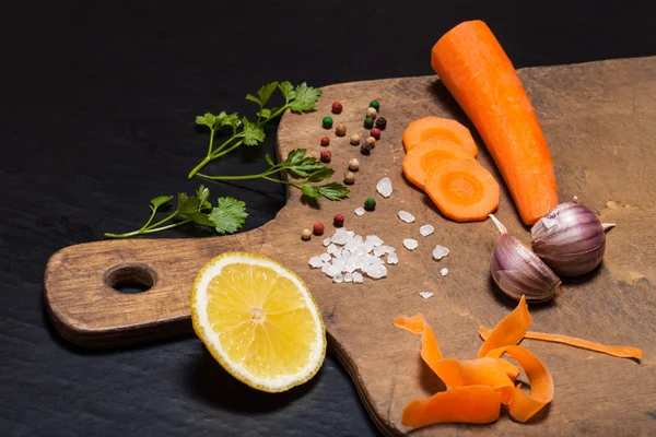 Соль, перец и овощи на старом деревянном фоне — стоковое фото