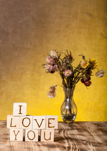 Cubos de madera con inscripción "I LOVE YOU" y ramo de fl seco — Foto de Stock