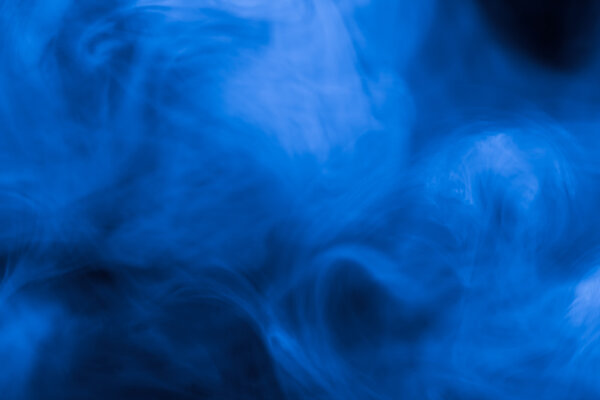 Cloud of smoke on black background. Selective focus. Toned.