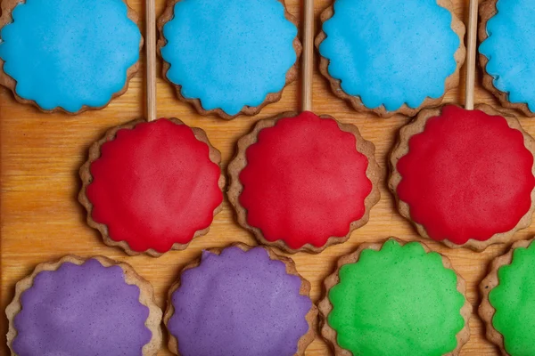 Пряничное печенье с цветной мастикой на палочках на старом woo — стоковое фото