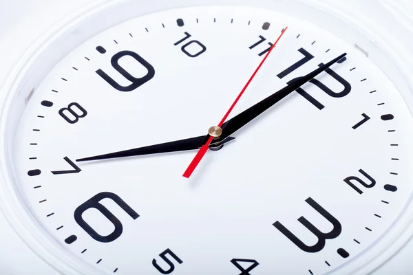 White wall clock with black arrows. Selective focus. Shallow dep — Stock Photo, Image