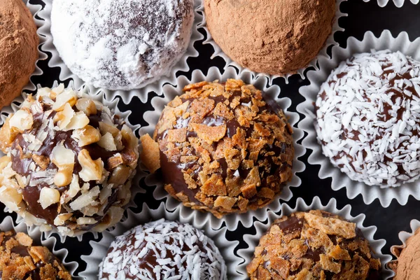 Chocolates caseiros redondos em diferentes tipos de decoração em papel su — Fotografia de Stock