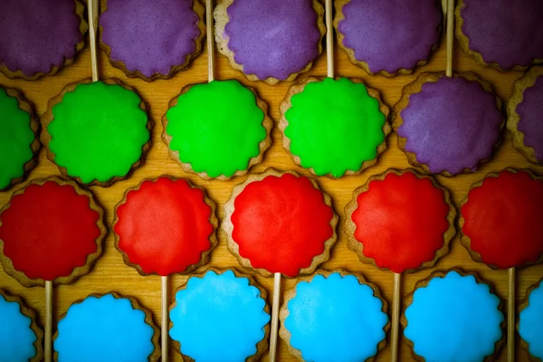 Gingerbread koekjes met gekleurde mastiek op stokjes op de oude woo — Stockfoto