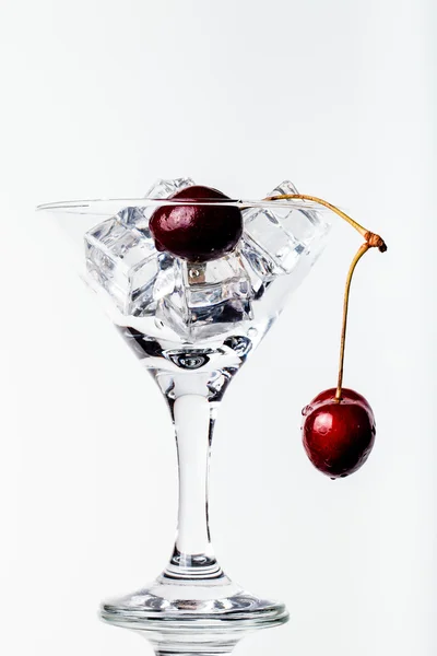 Baies de cerises dans un verre de martini sur fond blanc. tonique — Photo