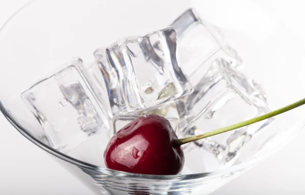 Baies de cerises dans un verre de martini sur fond blanc — Photo