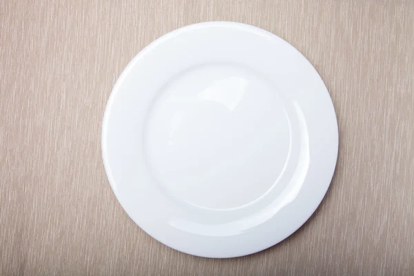 Empty white plate on grey napkin, top view — Stock Photo, Image