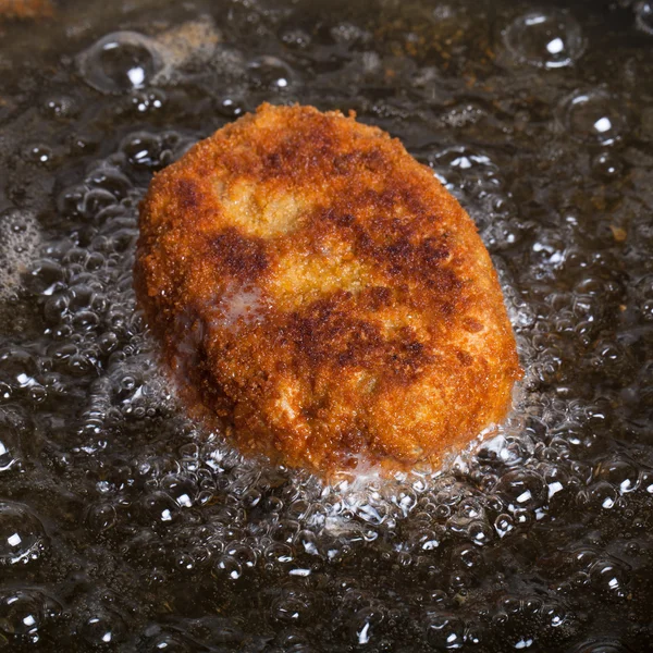 Cutlet fried in oil in a frying pan. Selective focus — Stock Photo, Image